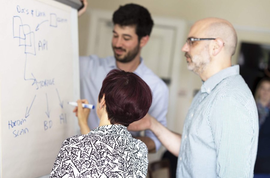team members mapping processes on a whiteboard